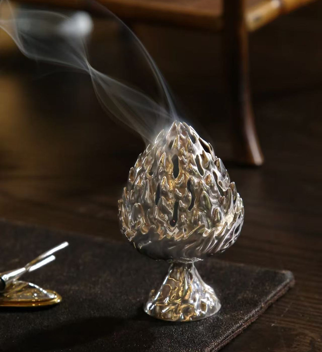Incense burner with smoke on a wooden surface